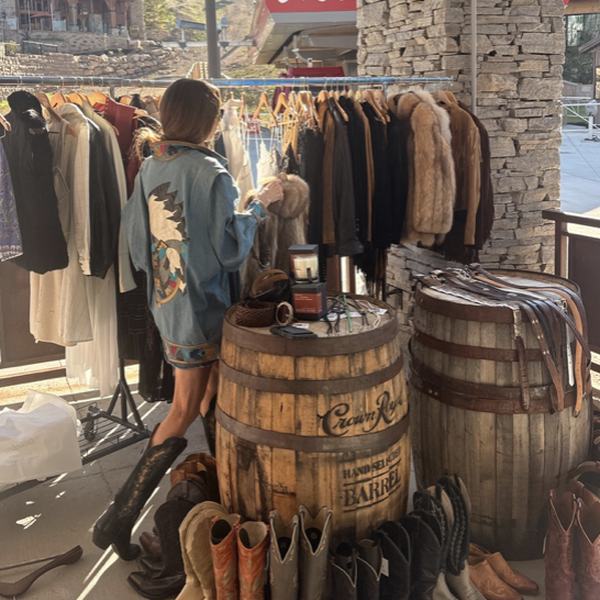 Racks of vintage coats above a row of western boots